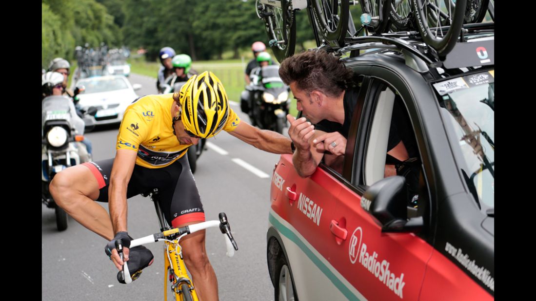Fabian Cancellara of team RadioShack-Nissan holds on to the team car as he makes an adjustment during the race Thursday.