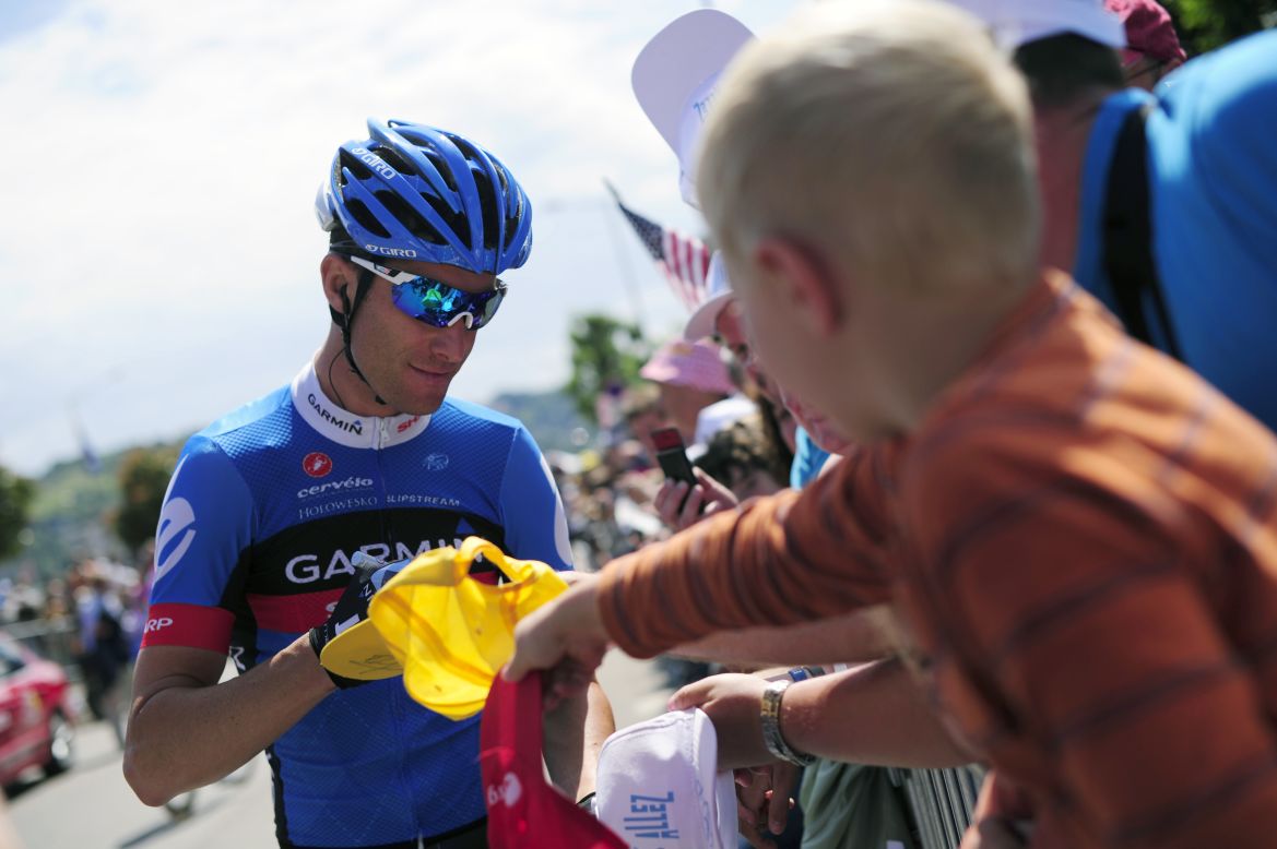 Christian Vande Velde of the Garmin-Sharp team signs an autograph for a fan before the beginning of Thursday's stage.