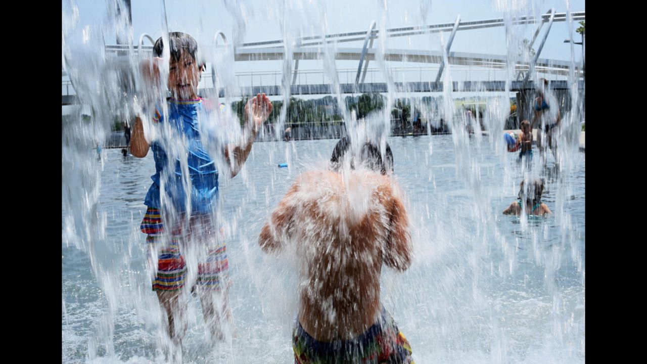 Ten-year-old Lilly Hwang-Geddes, left, of Ithaca, New York, plays in a fountain at the Yards Park on Thursday, July 5, in Washington.