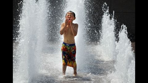 Six-year-old Spencer Hwang-Geddes of Ithaca, New York, cools off at the Yards Park on Thursday. Weather forecast predicted the hot weather will last through Sunday with possible daily triple-digit temperatures.