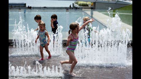 Chilren play in the fountain away form Thursday's scorching temperatires at the Yards Park.