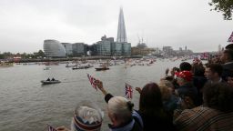 Crowds by the river cheer as the flotilla passes the Shard during the Thames Diamond Jubilee Pageant on the River Thames in London on June 3, 2012. Queen Elizabeth II sailed Sunday on a royal barge at the centre of a spectacular 1,000-boat river pageant on the Thames, the set-piece of celebrations to mark her diamond jubilee. AFP PHOTO / POOL / JUSTIN TALLIS (Photo credit should read JUSTIN TALLIS/AFP/GettyImages) 