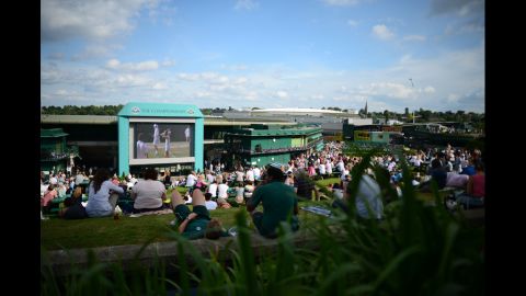 Spectators follow the day's matches on the big screen in the afternoon sun on Murray Mound on Thursday.