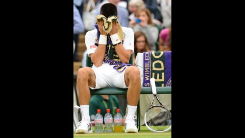 Novak Djokovic buries his head in his towel during a break between games against Roger Federer on Friday.