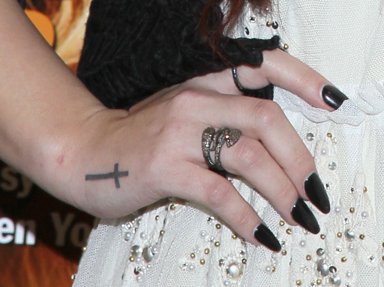 Singer/actress Demi Lovato displays a tattoo of a cross during a book signing.