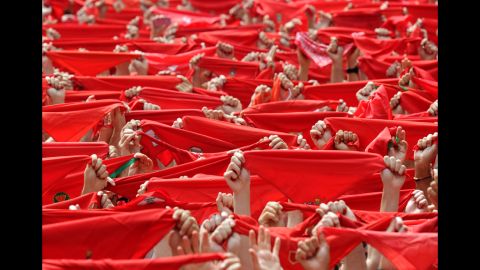 People hold red handkerchiefs in the air during the opening ceremony Friday. The run in Pamplona started 400 years ago.