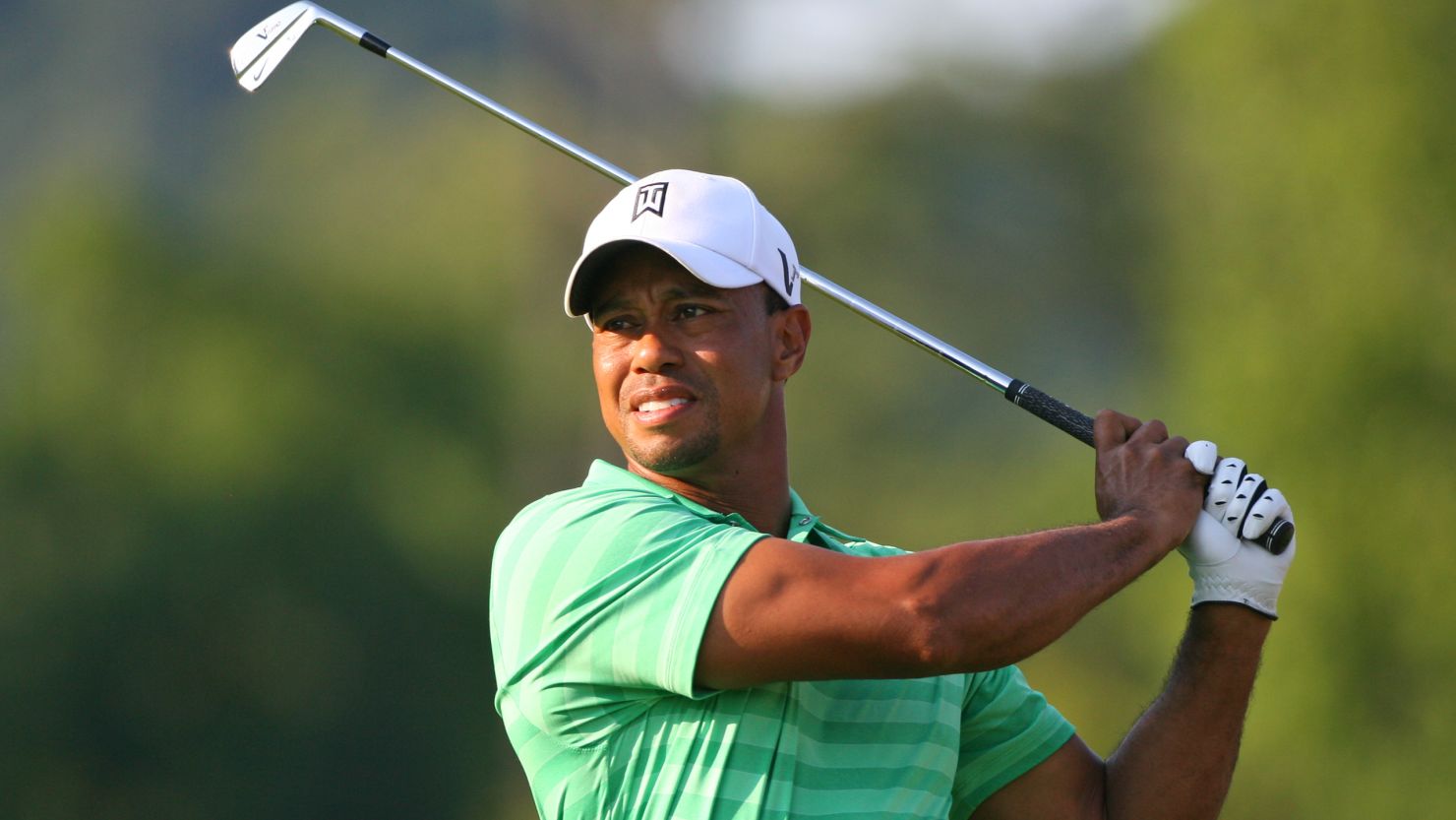 Tiger Woods plays an approach in gathering gloom at the Greenbrier Classic where he missed the cut.