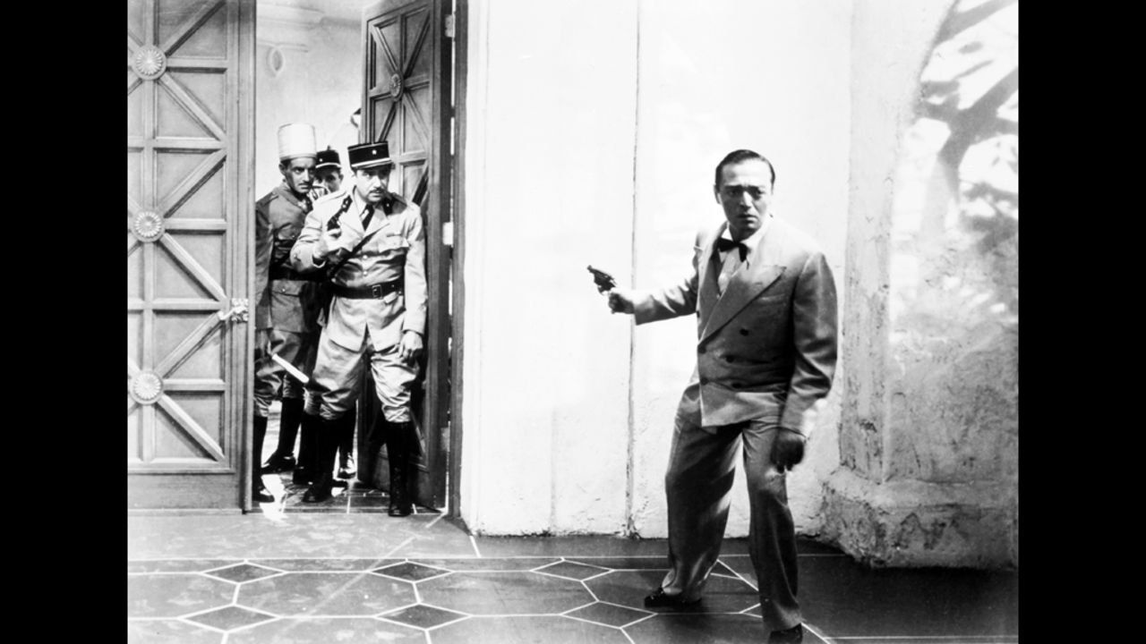 Ugarte holds the letters of transit that many refugees waiting in Casablanca would like to get their hands on. Here he brandishes a gun as he attempts to flee from French authorities.