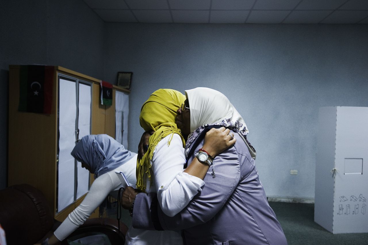 Two Libyan election workers embrace after voting ends at a Tripoli polling station.