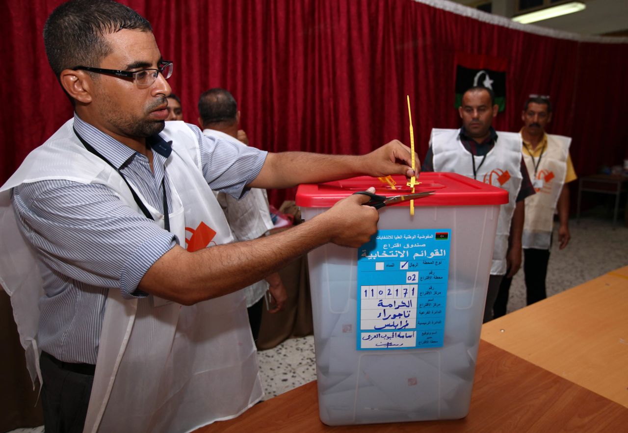 A Libyan election official opens a ballot box at a Tajura polling station.