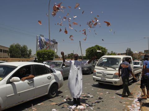 A Libyan protester throws torn ballots in the air outside a Benghazi polling station.