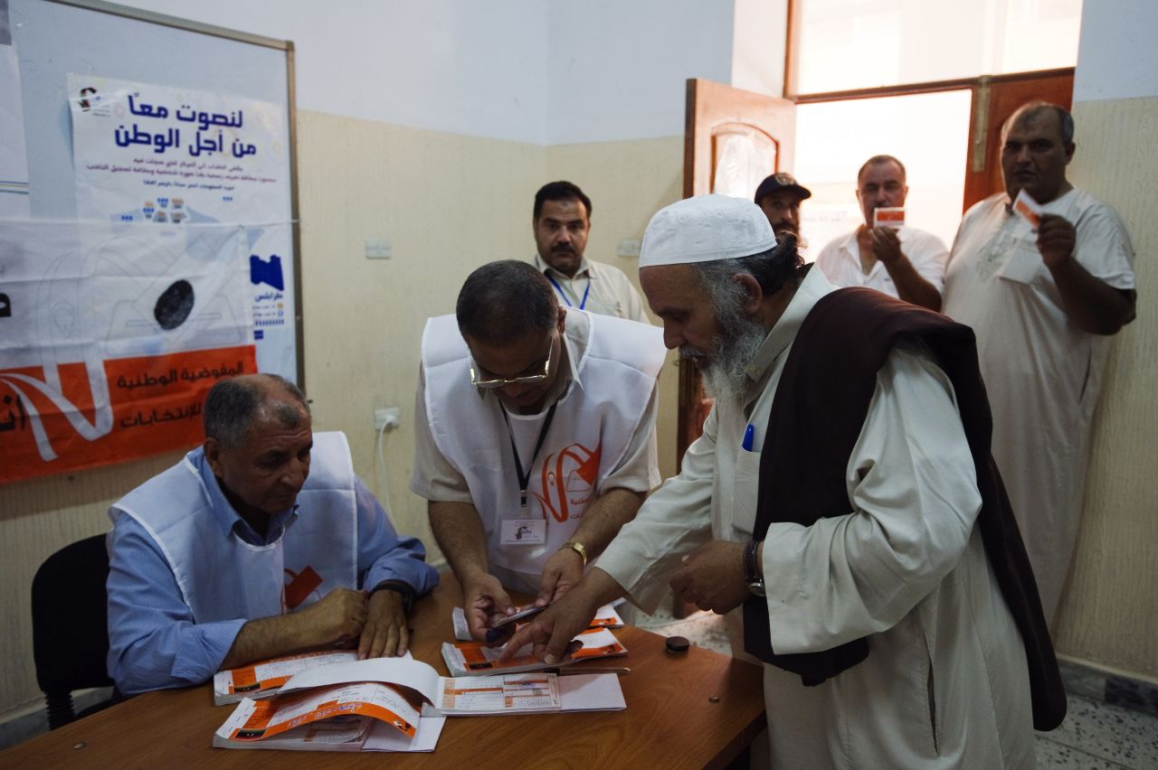 Libyan election workers check the identification card of a voter at a Tripoli polling station.