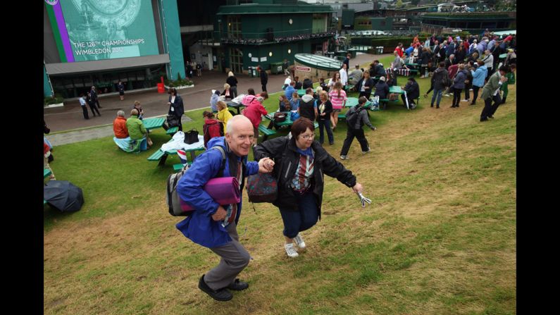 Spectators race to claim a vantage point on Murray Mount after the gates opened at the venue on Sunday.