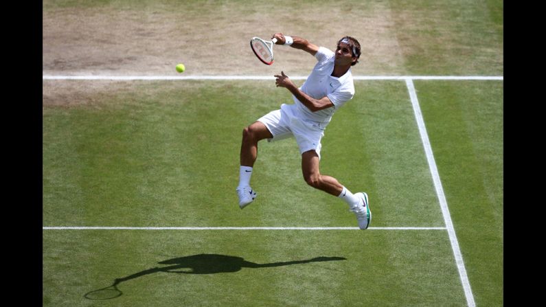 Federer jumps and returns a shot to Murray on Sunday.