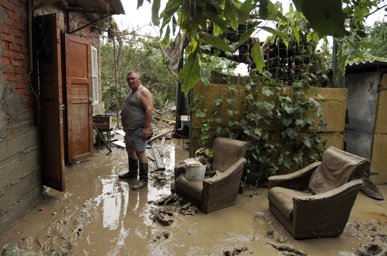 A man stands in the flooded ruin of his home in Krymsk, Russia, on Sunday.