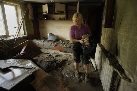 A resident of Krymsk inspects her home, damaged by the flooding that followed heavy rains that began Friday, pushing rivers and streams over their banks overnight.