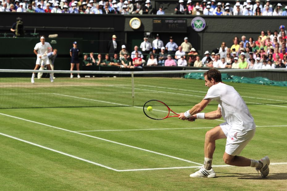 Murray returns a double-handed backhand to Federer during the men's singles Wimbledon championship on Sunday. 