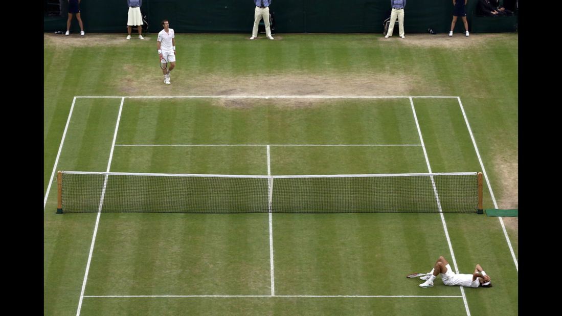 Federer lies on the grass court at the All England Tennis Club upon winning match point during the men's singles final against Murray on Sunday.