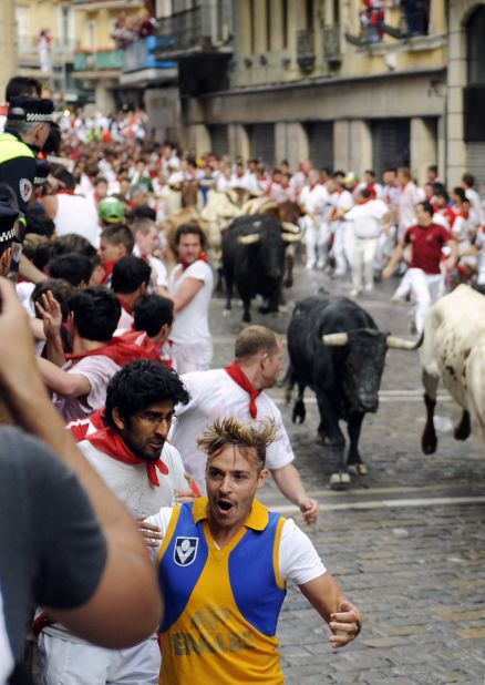 Participants seek safety during the first bull run on Saturday.