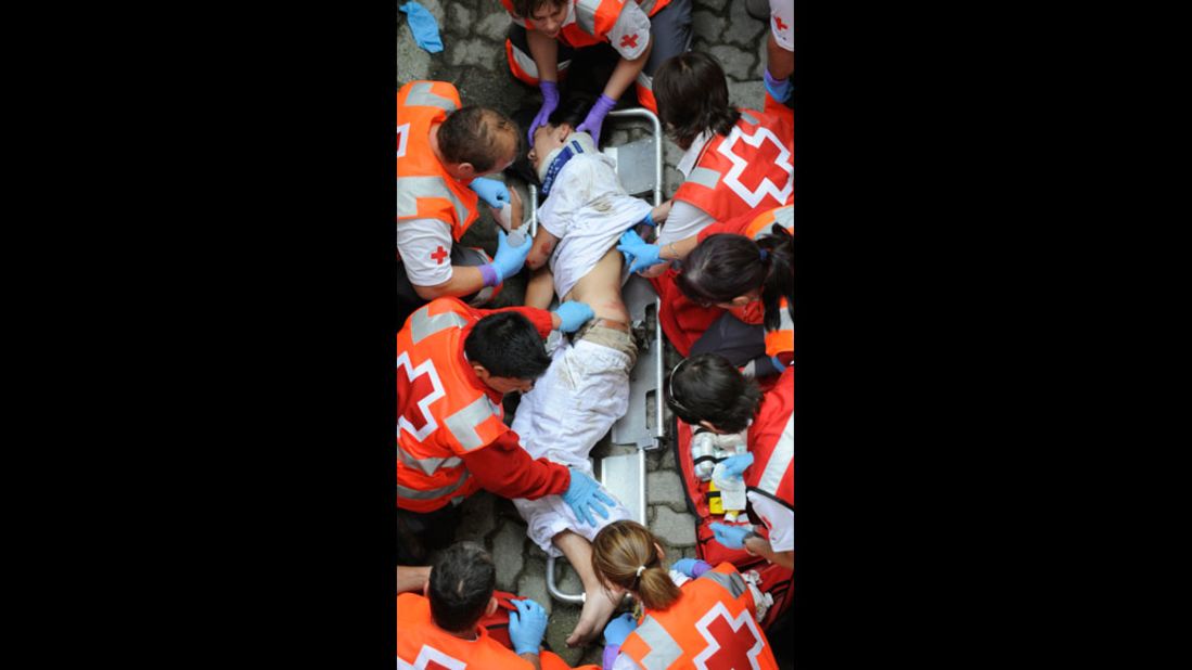 A man receives medical assistance after being injured during the first San Fermin Festival bull run.