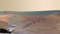 NASA has unveiled the latest panoramic view of Mars -- as seen by its venerable rover, Opportunity. The image shows an impact crater blasted billions of years ago, alongside fresh tracks created by the rover itself.