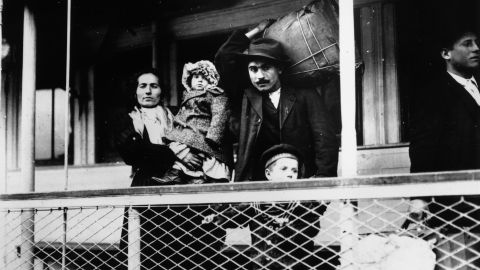 An Italian immigrant family on board a ferry from the docks to Ellis Island, New York. 