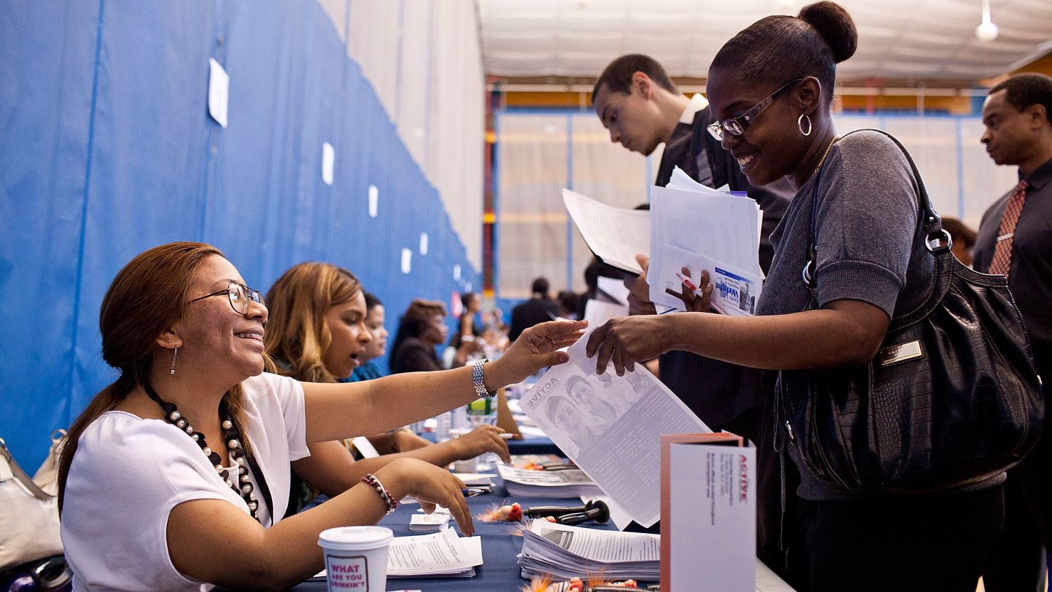  A woman speaks to a potential employer at a New York state jobs fair in the Harlem Armory in New York on June 7.
