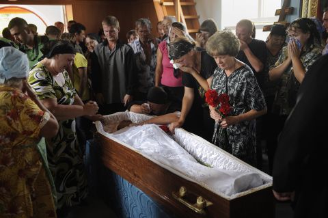 Friends and relatives surround the body of Ostapenko, who was killed during flooding in the village of Moldavskoe.
