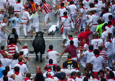 A bull chases revelers on the third day of the annual Running of the Bulls.