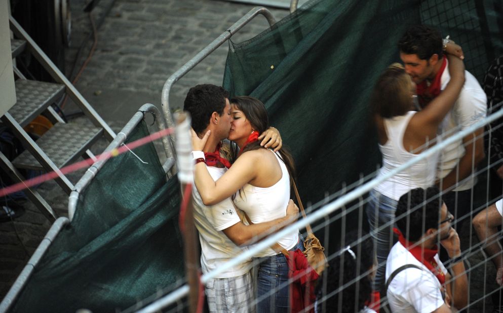 Two couples kiss as they wait for the fourth bull run to begin Tuesday.