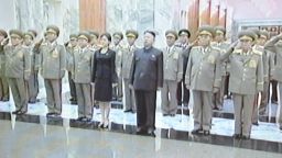 This screen grab taken from North Korean TV on July 9, 2012 shows an unidentified woman accompanying North Korean leader Kim Jong-Un (C) during his visit to Kumsusan Palace in Pyongyang on July 8, 2012 to pay tribute to his late grandfather Kim Il-Sung on the anniversary of his death in 1994. A mystery woman pictured accompanying North Korea's new leader Kim Jong-Un to recent events has prompted speculation in Seoul about whether she is his partner or his younger sister. ----
