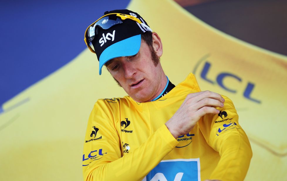 Bradley Wiggins pulls on the yellow jersey after successfully defending the maillot jaune after winning his first Tour de France stage victory in the time trial between Arc et Senans and Besancon.