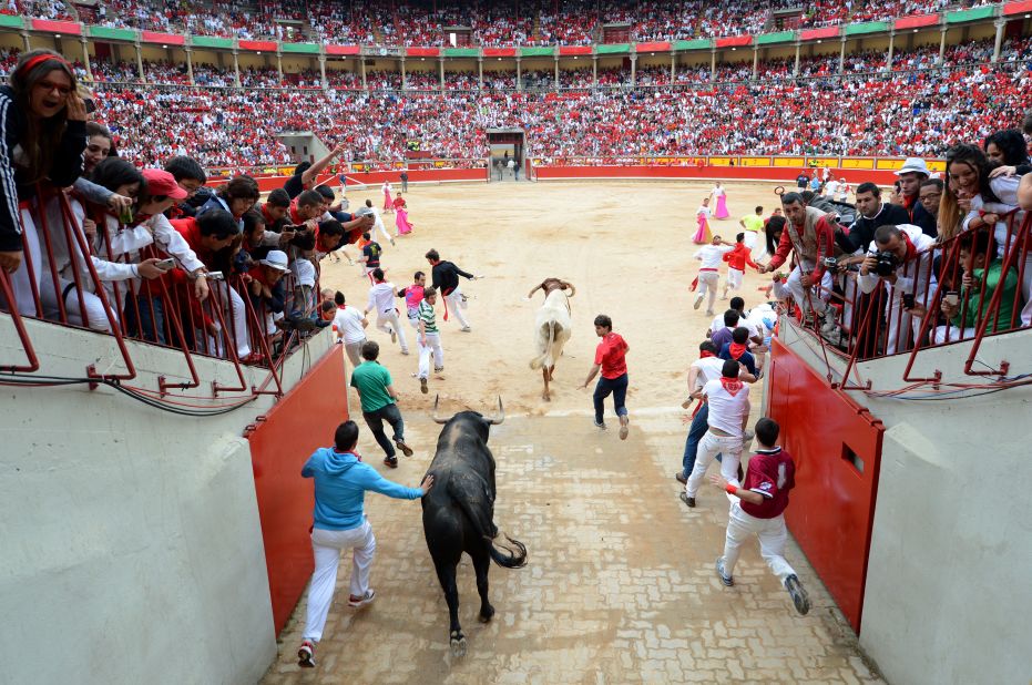 Participants run through the entrance of the bullring Wednesday on the fifth day of the festivities.