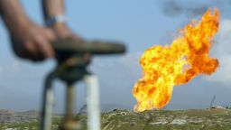 An oil worker turns a valve on an Iraqi oil field