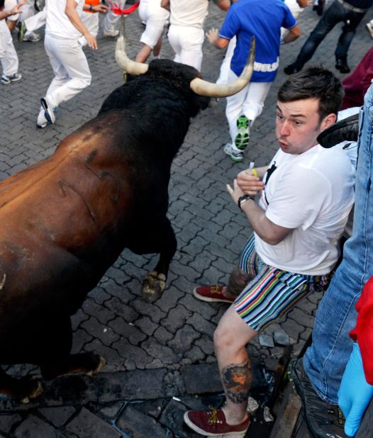 A participant in the running braces as a number of bulls pass close by on Thursday.