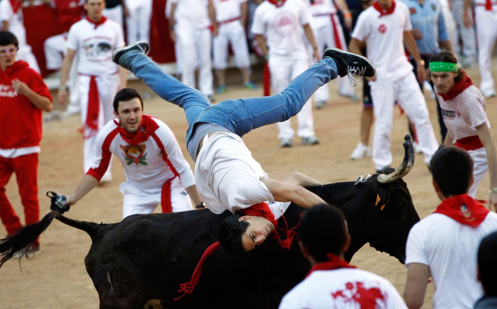 A man is thrown by a bull during the sixth day of the running of the bulls at the San Fermin festival on Thursday, July 12. 