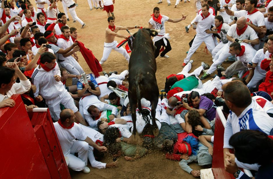 A bull jumps over revelers as others clear the way as the animals enter the bullring on Thursday.