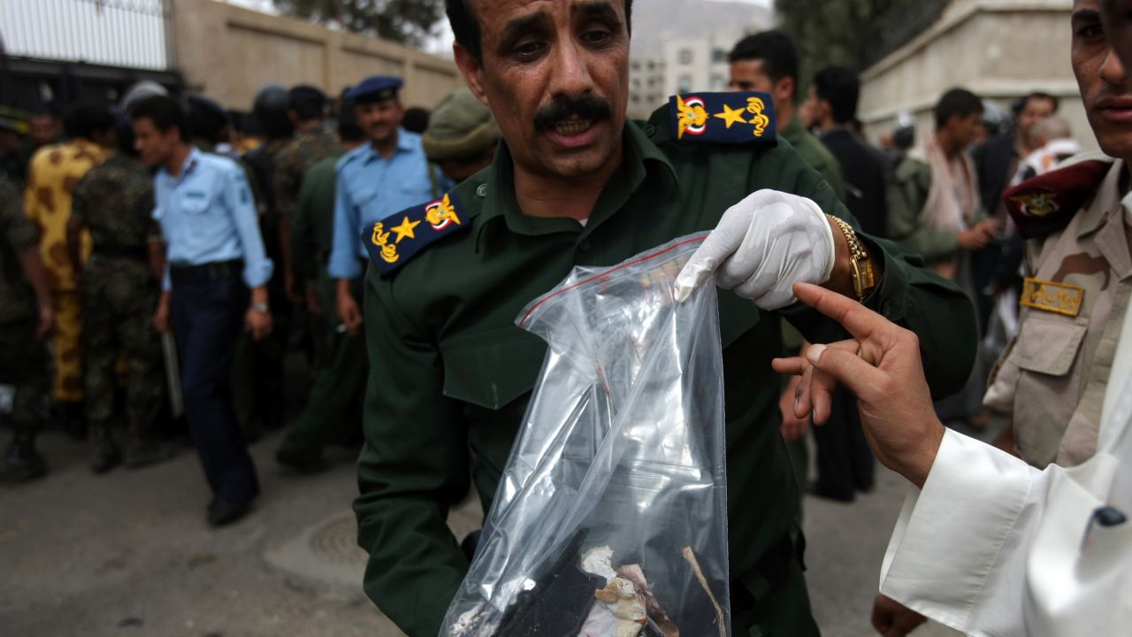 A Yemeni police officer holds evidence at the site of an explosion at a police academy in Sanaa on July 11, 2012.