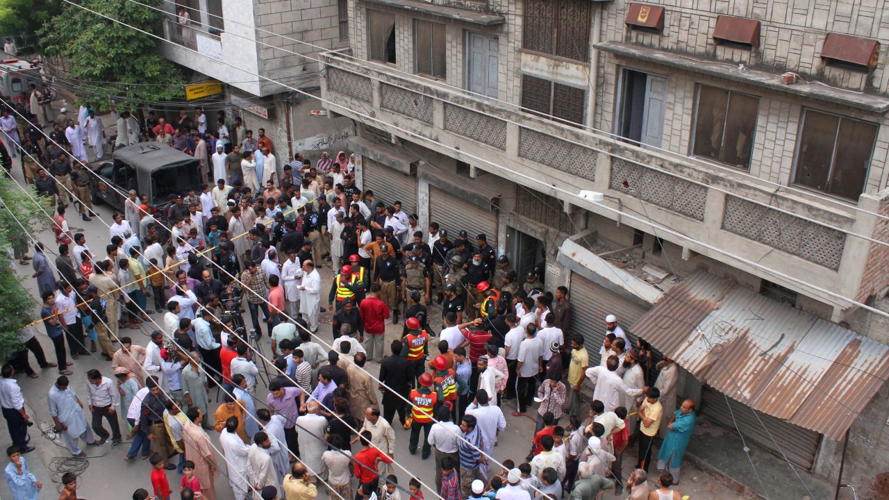 Pakistani residents and rescuers gather outside the police hostel after an attack on prison guards in Lahore on Wednesday. 