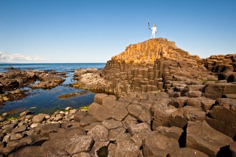 Triathlete Peter Jack holds the Olympic flame while on the Giant's Causeway in Northern Ireland on June 4.