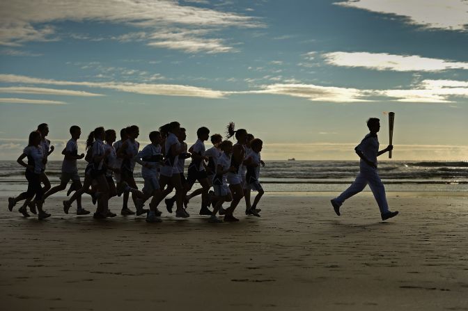 Joseph Forrester, 12, and children from Madras College run along West Sands in St. Andrews, Scotland, on June 13.