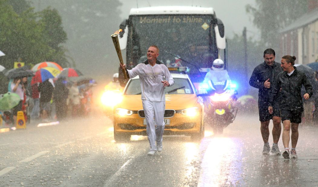 Retired police officer Glenn Chambers carries the flame through heavy rain in Lincoln, England, on June 28.
