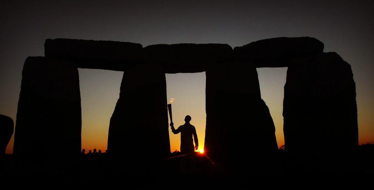 Olympic gold medalist and former sprinter Michael Johnson carries the flame at Stonehenge onThursday.