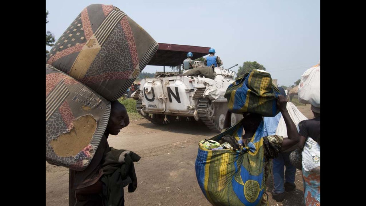 A UN peacekeepers travel along the road with refugees headed for the Kiwanja refugee camp.