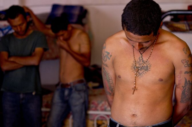 Immigrants from Central America bow their heads in prayer at a shelter outside Mexico City. Many of them are on their way to the United States.