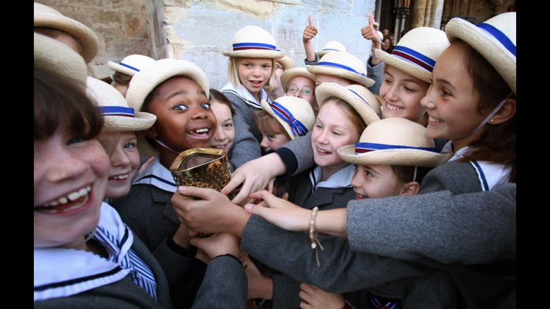 Schoolgirls outside Salisbury Cathedral on Thursday hold the torch carried by retired sprinter and four-time gold medal winner Michael Johnson.