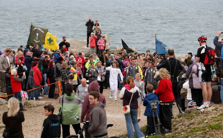Thomas Mules carries the Olympic flame on Pulpit Rock, Portland Bill, on Friday, July 13.