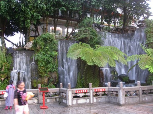 A waterfall welcomes visitors inside the first gate.