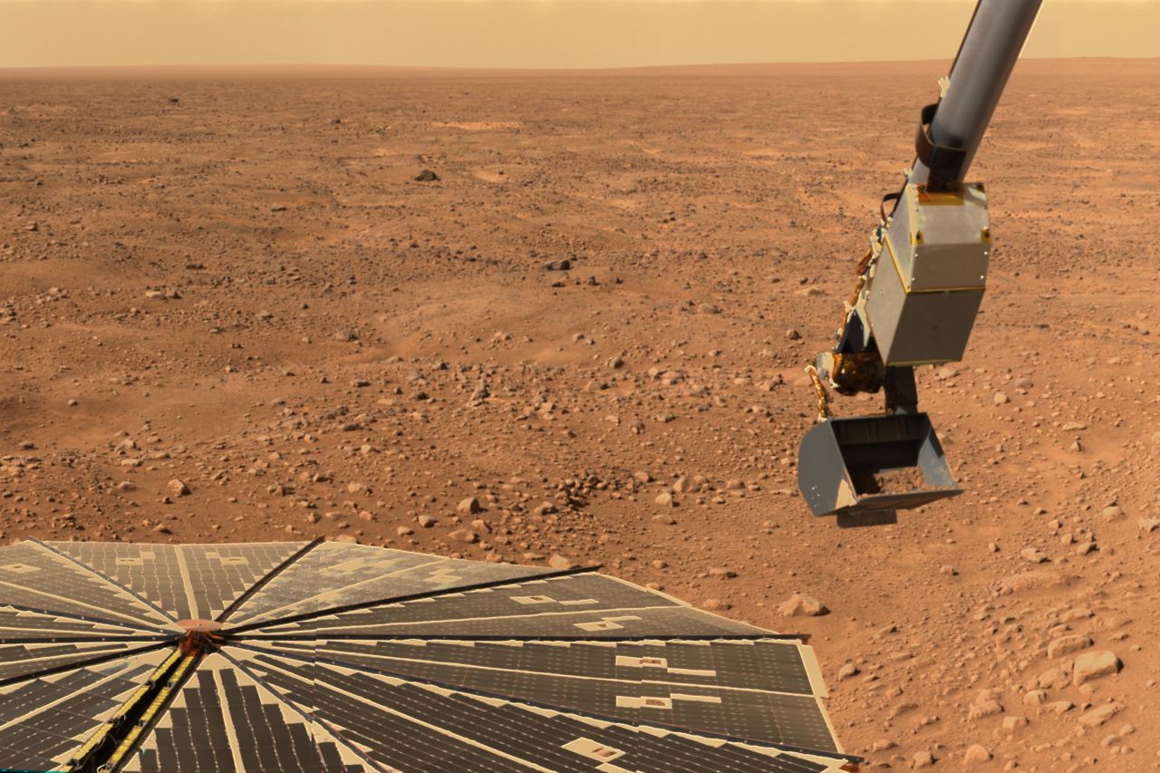 Phoenix's robotic arm scoops up a sample on June 10, 2008, the 16th Martian day after landing. The lander's solar panel is seen in the lower left.
