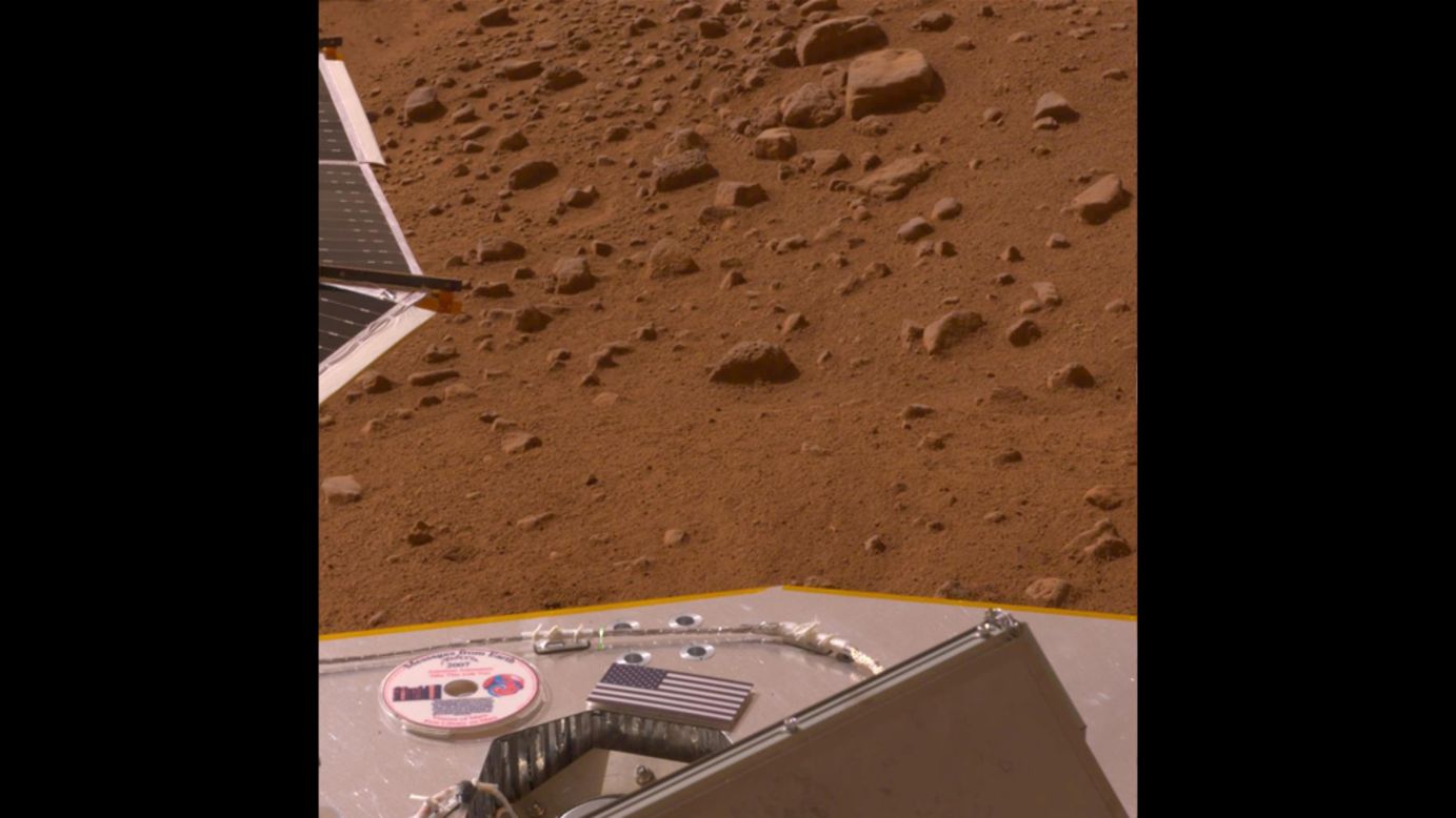 Una bandera de Estados Unidos y un DVD con un mensaje para futuras exploraciones en Marte, historias de ciencia ficcion y arte acerca del planeta, y los nombres de 250.000 personas sobre la cubierta de Phoenix en el 2008.